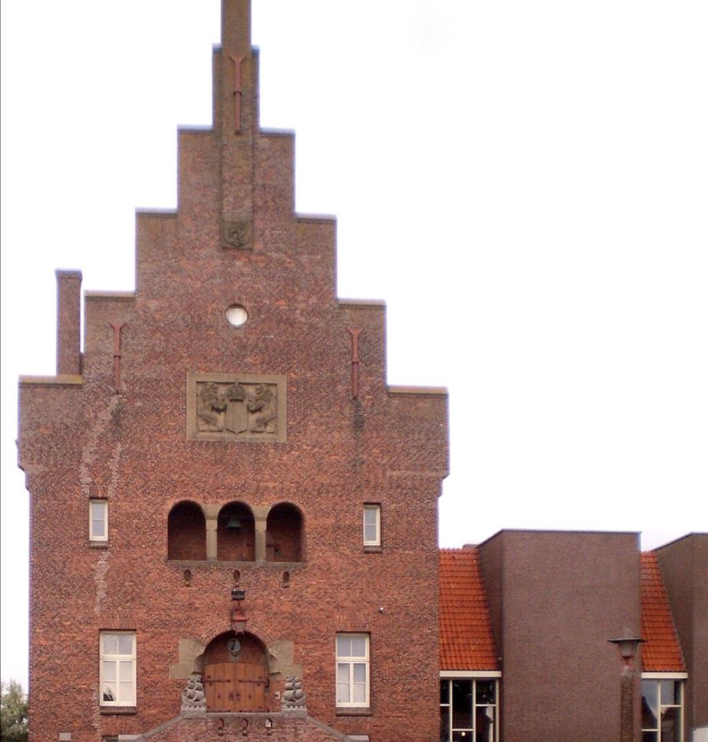 Voorgevel van het Stadsmuseum: een hoog bakstenen gebouw met trapgevel en een houten deur