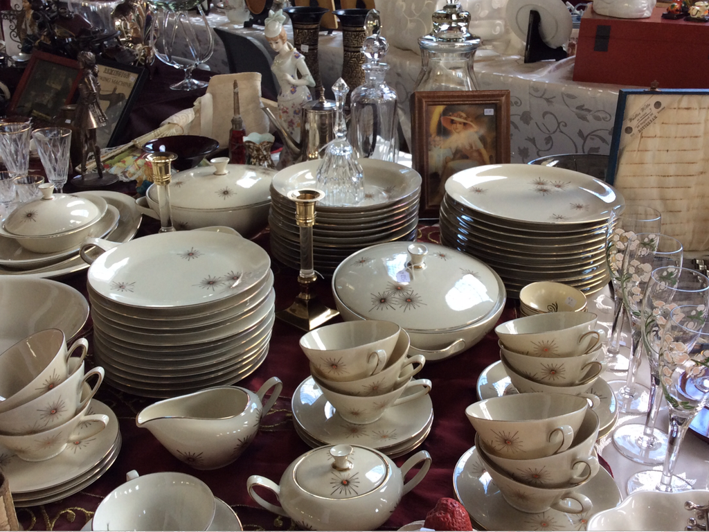 White tableware with a star pattern: plates, cups and a small milk jug on a red cloth