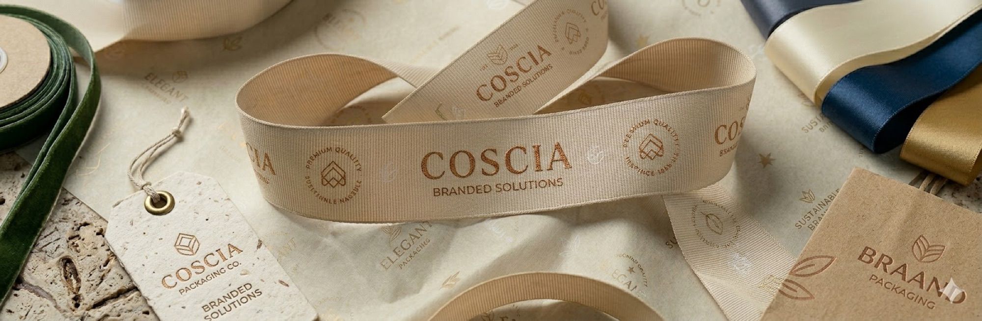 Custom beige grosgrain ribbon with repeated COSCIA logo for branded gift packaging