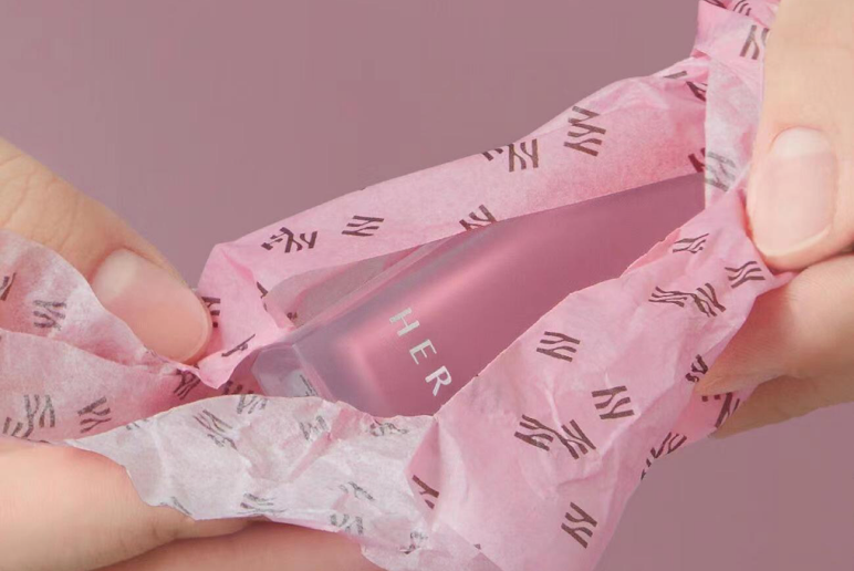 Pink branded tissue paper wrapping a product
