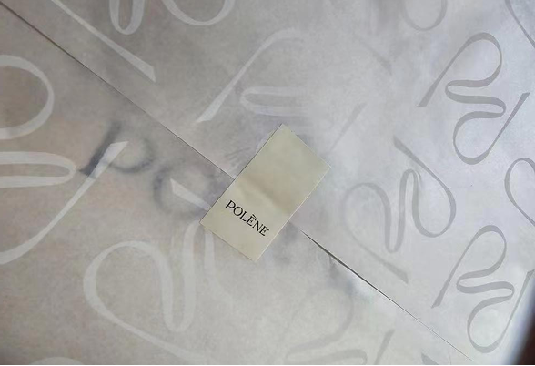 Close-up of Polène white-on-white logo tissue paper with brand card