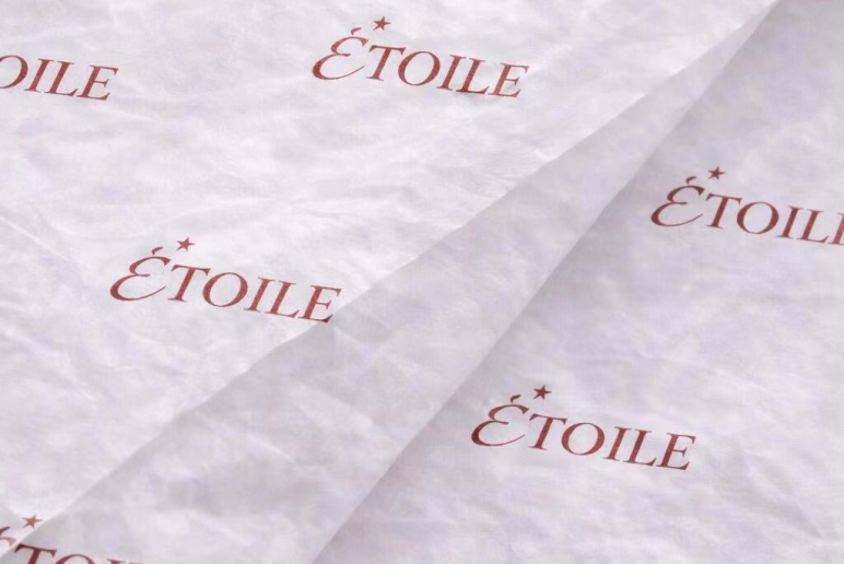 White tissue paper with repeating blue monogram print