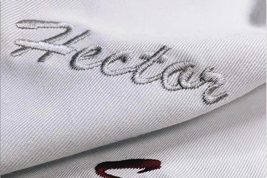 Gray embroidered script logo on white cotton fabric for premium custom pouches