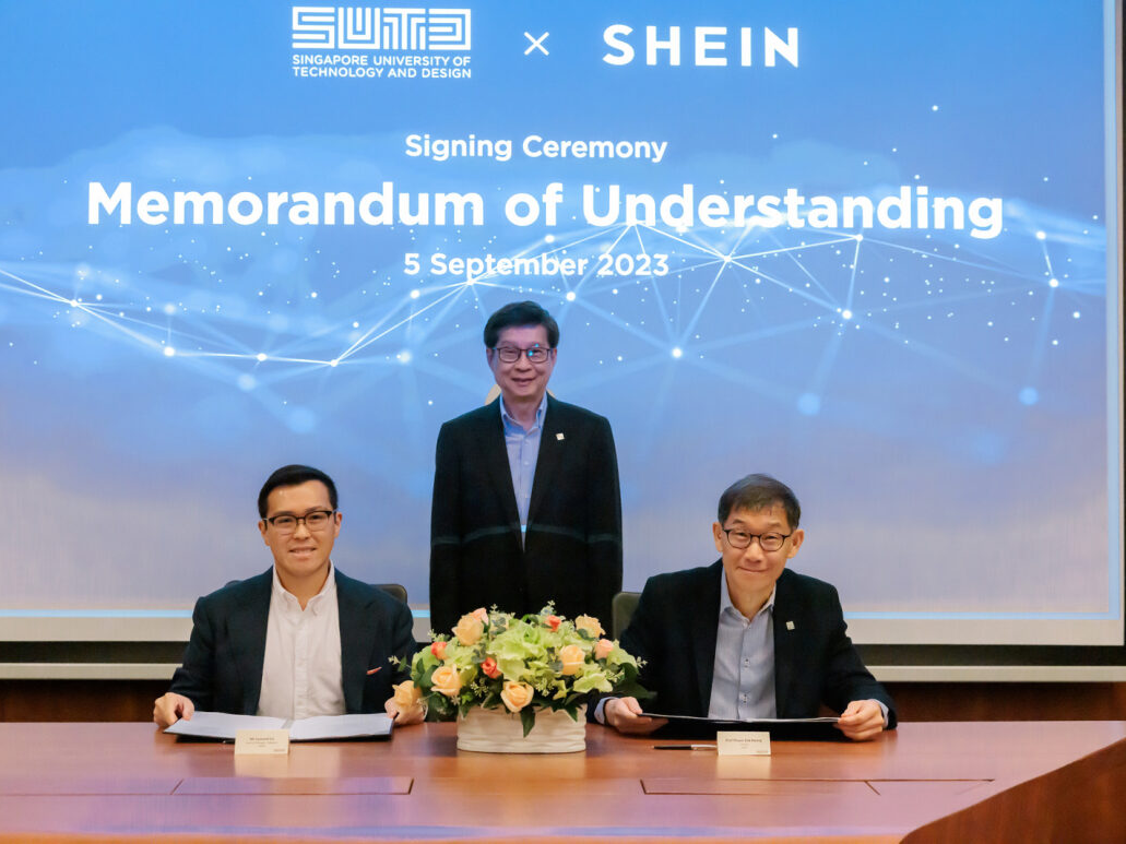 Three people at a table during a signing ceremony between SUTD and SHEIN