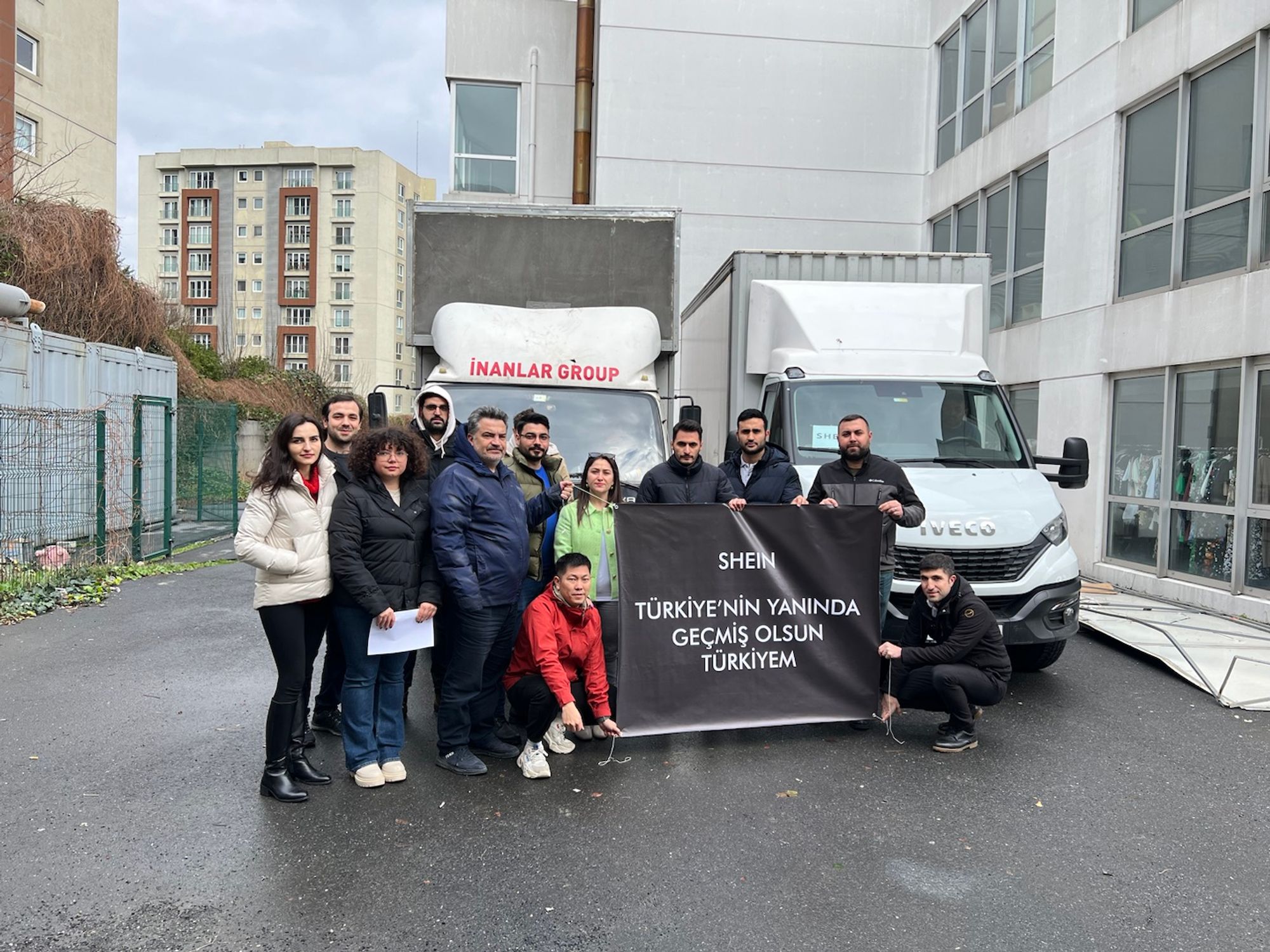 A group holding a support banner for Turkey in front of two trucks