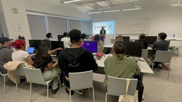 Students in a classroom watching a presentation about SHEIN X