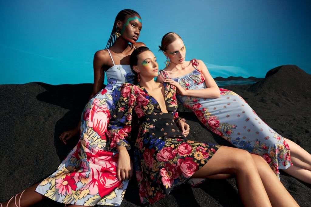 Three models posing in different dresses