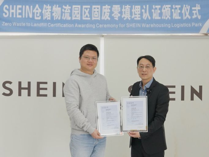 Two people standing together and holding certificates