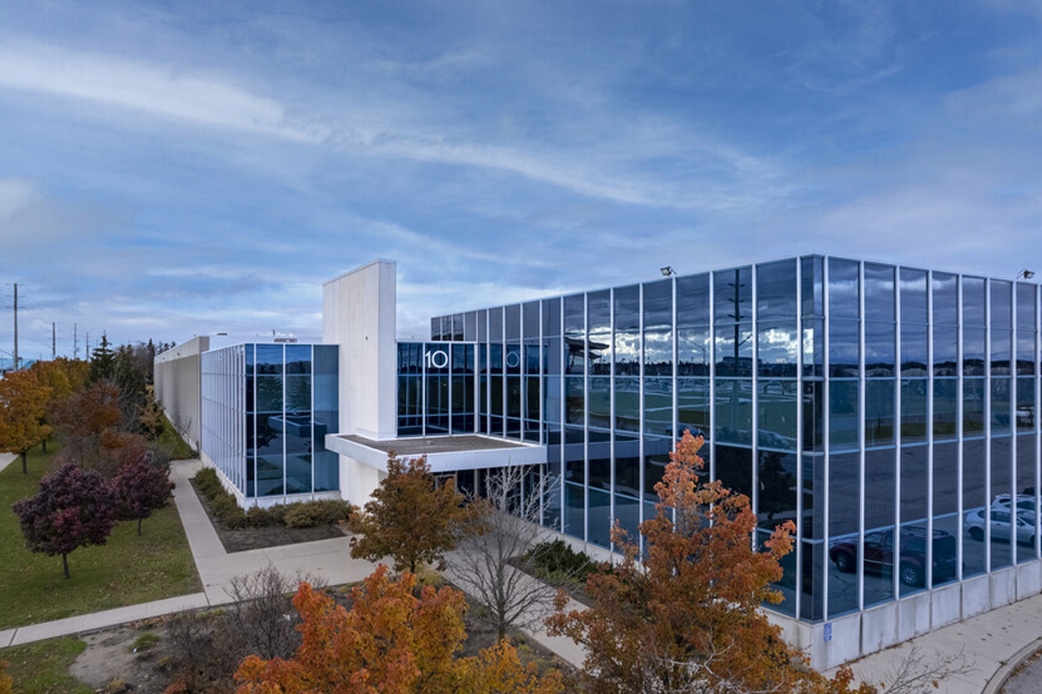 Modern glass office building with autumn trees outside
