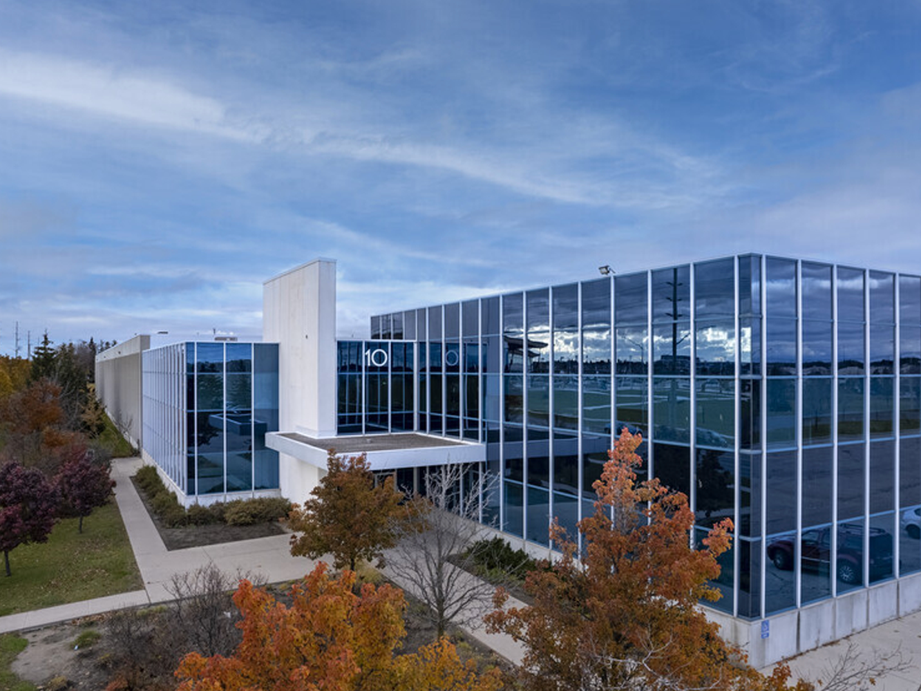 Modern glass office building with autumn trees outside