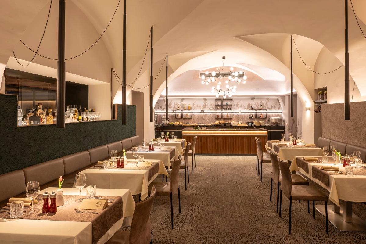 Restaurant Fischer in Marchtrenk mit historischem Gewölbe, stilvoll gedeckten Tischen und moderner Beleuchtung.