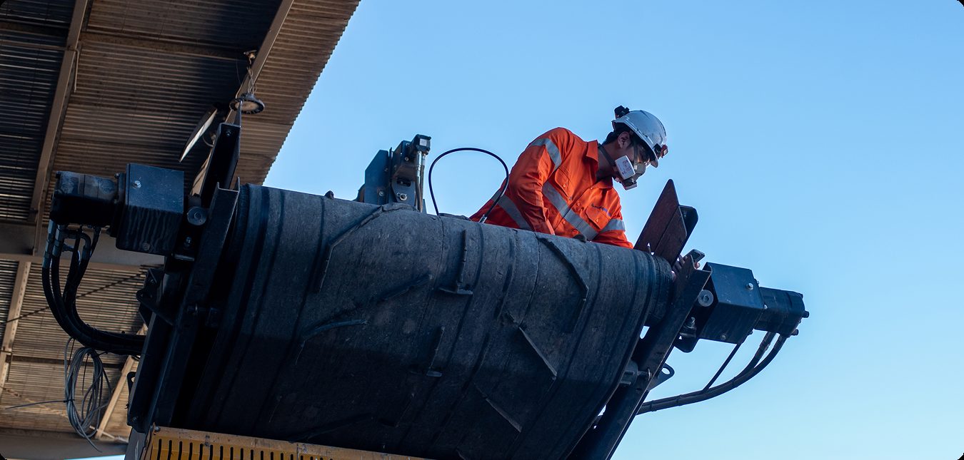Technician in an elevated work platform servicing fixed plant
