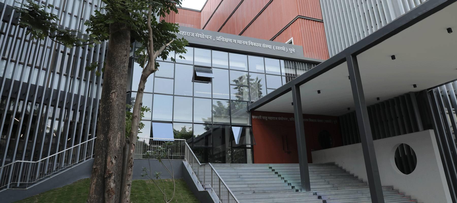 SARTHI institute, Pune: glazed entrance between corrugated red and louvred grey volumes