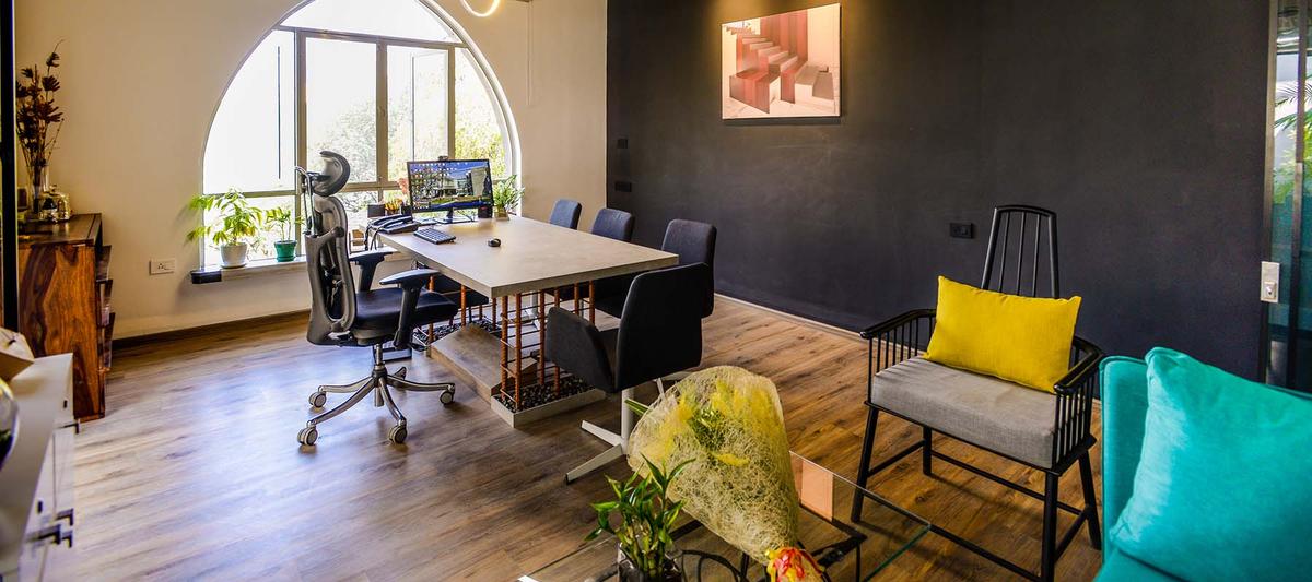 Studio lounge and drawing desk beside an arched window