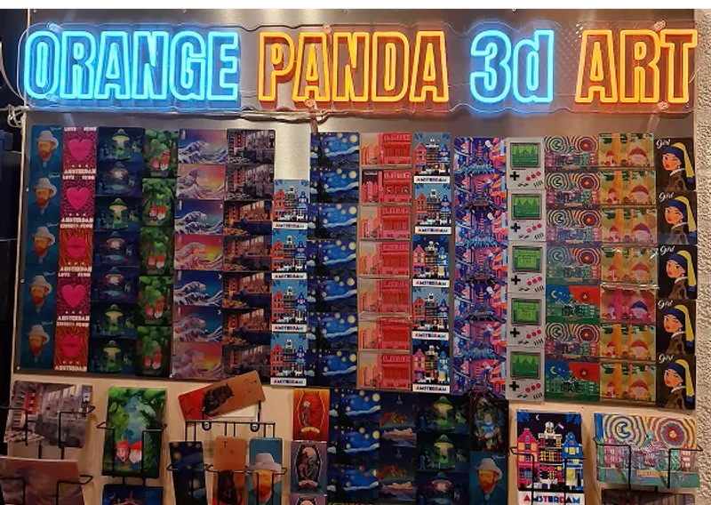 Orange Panda 3D Art neon sign above a wall of lenticular postcards