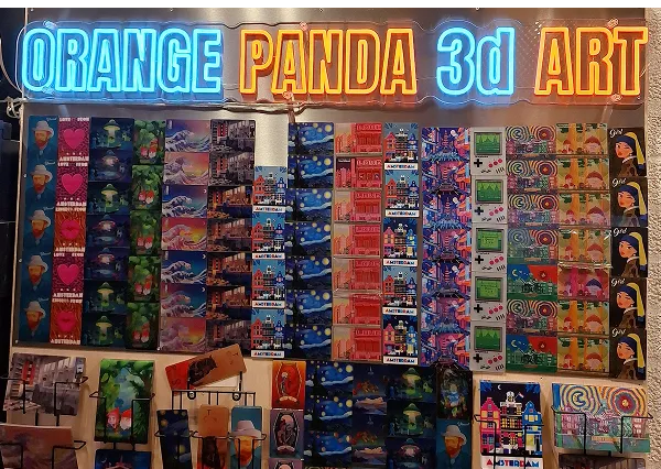 Orange Panda 3D Art neon sign above a wall of lenticular postcards