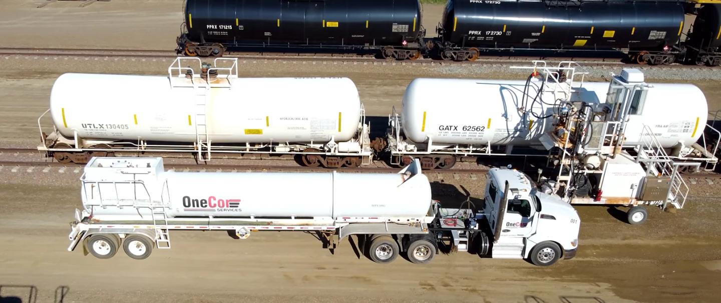 Aerial view of a OneCor tanker truck beside rail tank cars at a terminal