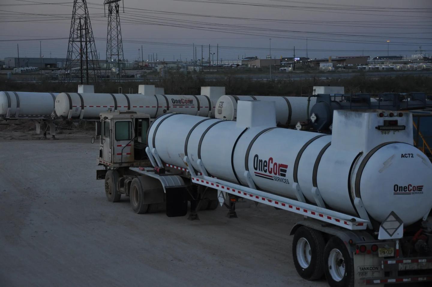 OneCor acid tanker trailers staged at a terminal at dusk