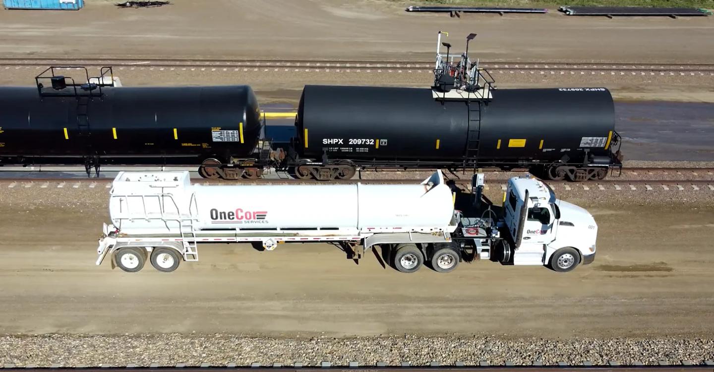 Aerial view of a OneCor tanker truck alongside rail tank cars