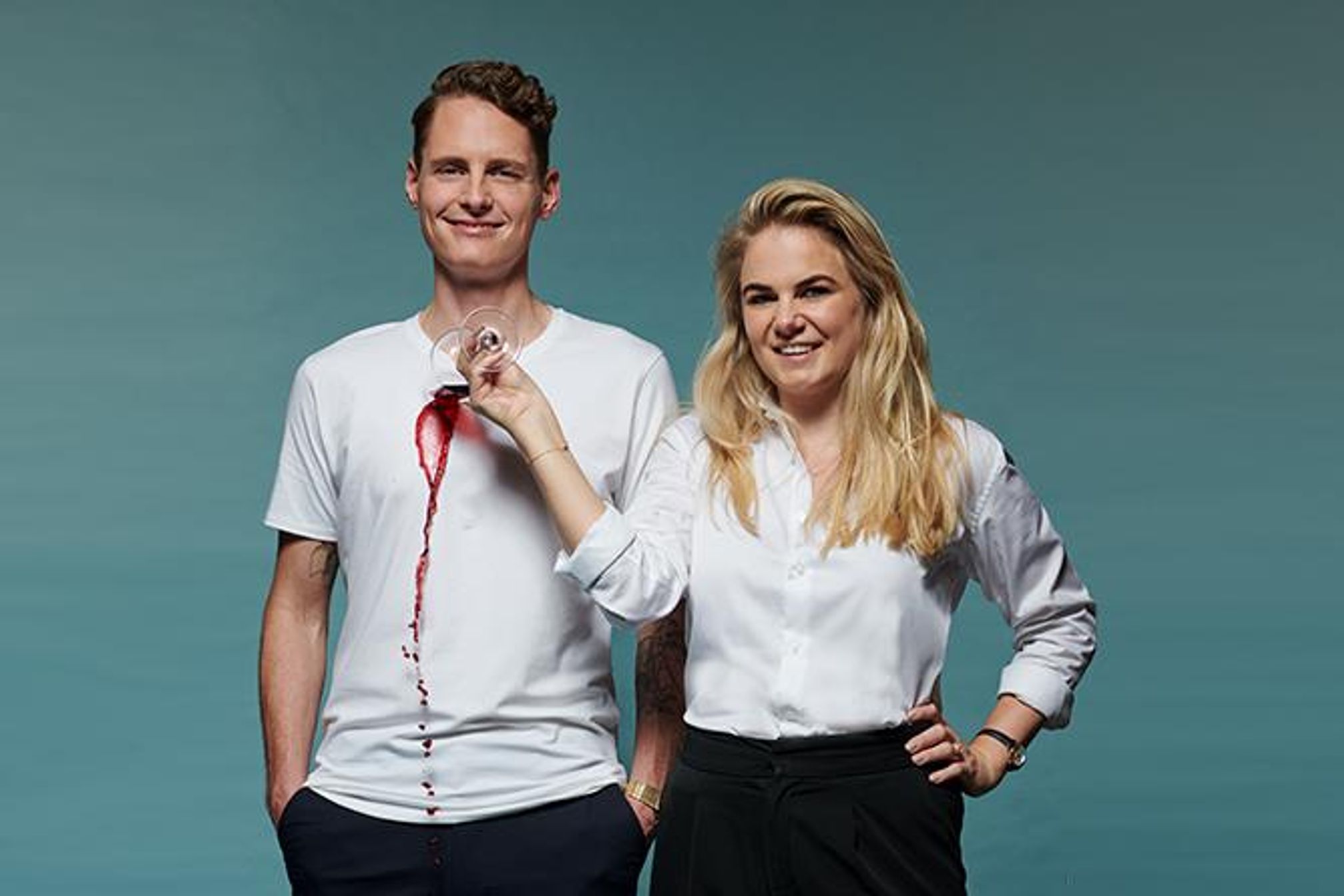 Man and women spilling red wine on white shirt