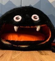 A stuffed drop spider sitting on a hardwood floor