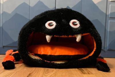 A stuffed drop spider sitting on a hardwood floor