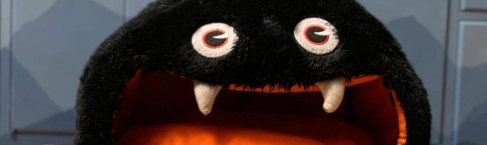 A stuffed drop spider sitting on a hardwood floor