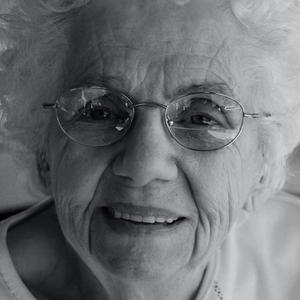 A black and white picture of an old lady smiling.