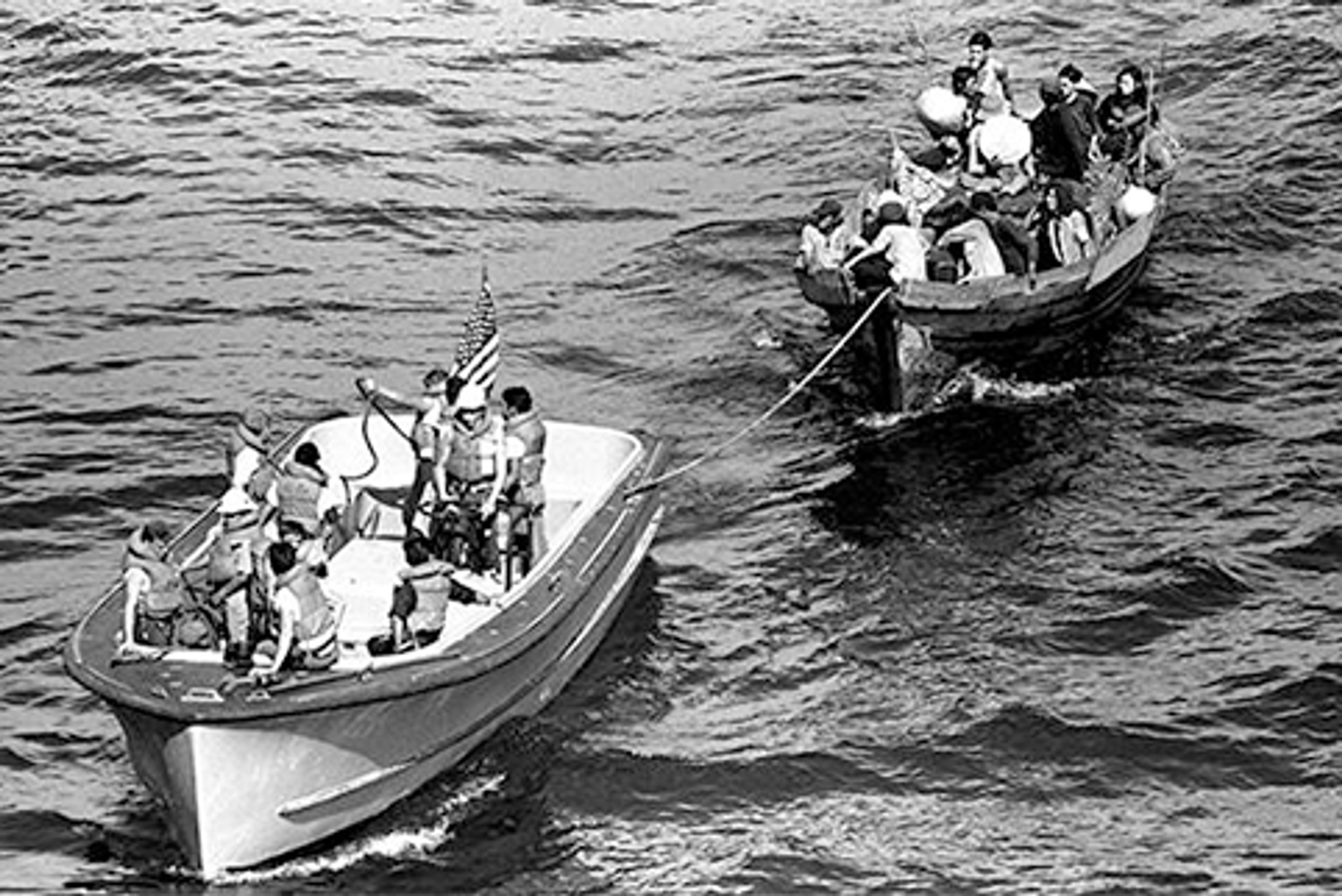 A life boat from the USS BLUE RIDGE (LCC 19) tows a Vietnamese fishing boat to the amphibious command ship. 35 Vietnamese refugees were rescued 350 miles north of Cam Ranh Bay, Vietnam, after spending eight days at sea, May 15, 1984. *National Archives.