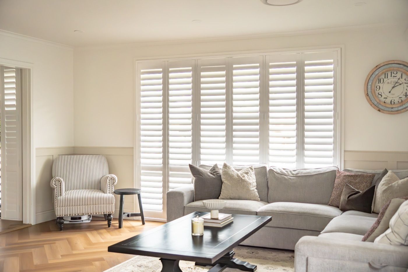 Plantation shutters closed to the street and still bright inside — the reason shutters win on a front-facing room.