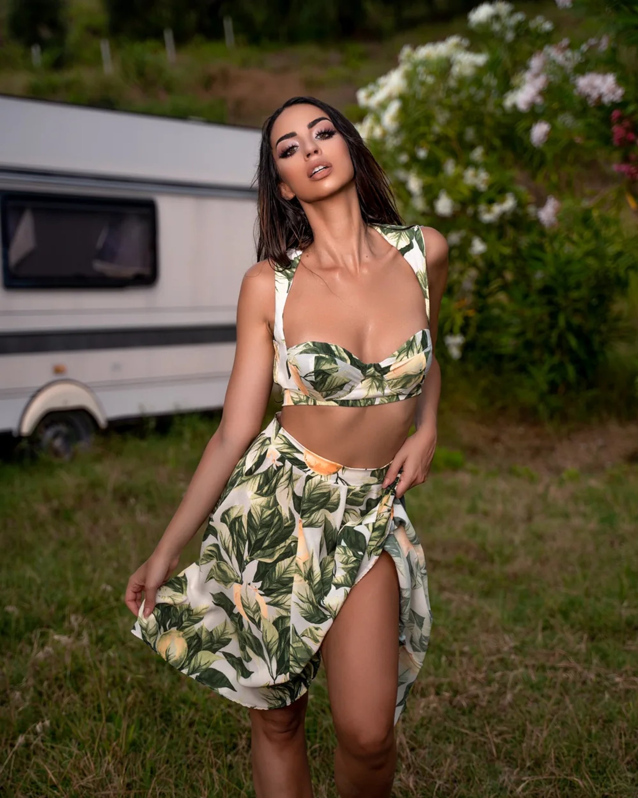 Botanical fashion portrait beside a caravan in summer light — photograph by Ergys Shehu.