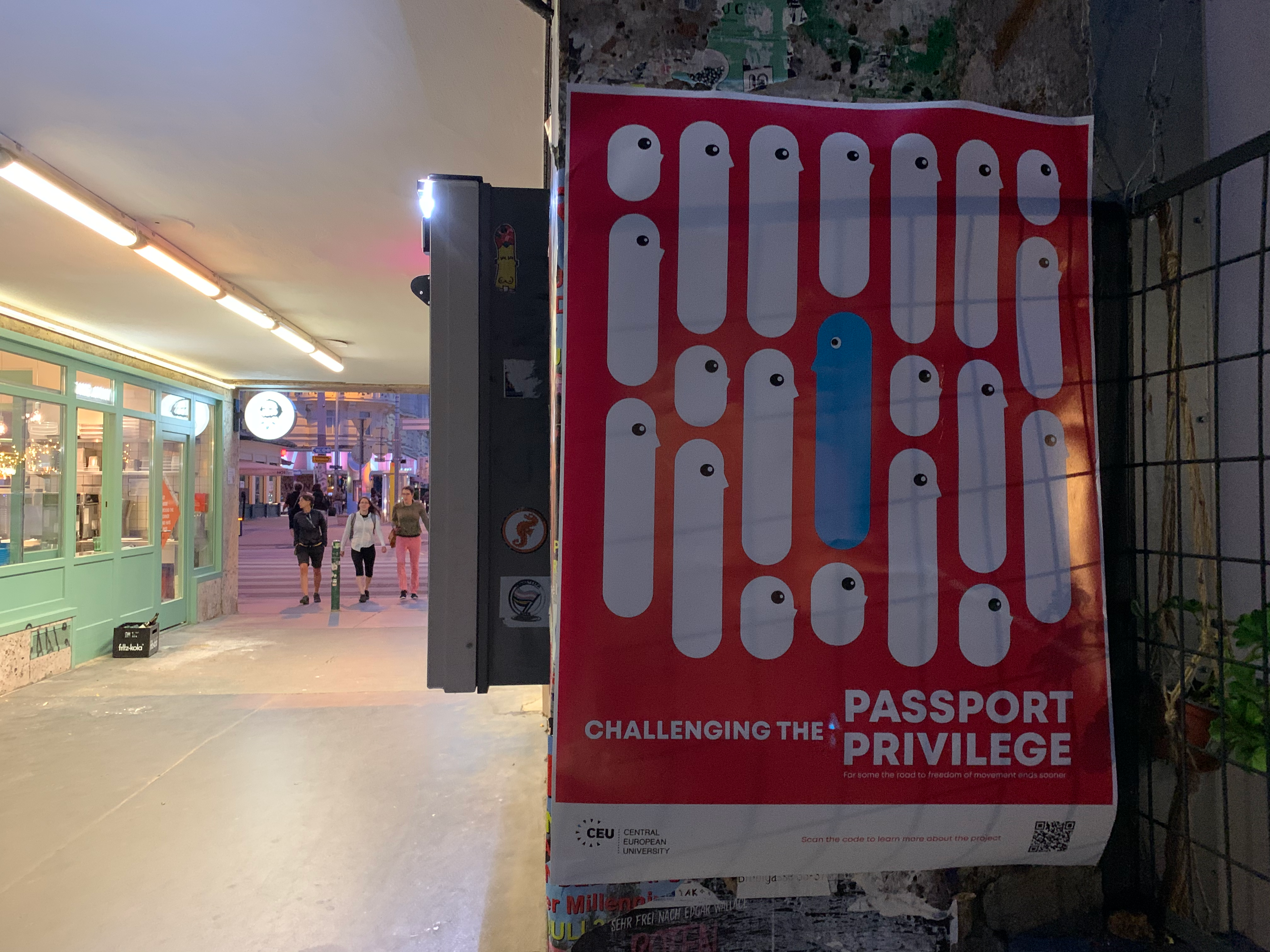 Red “challenging the Passport Privilege” poster hung in a public walkway