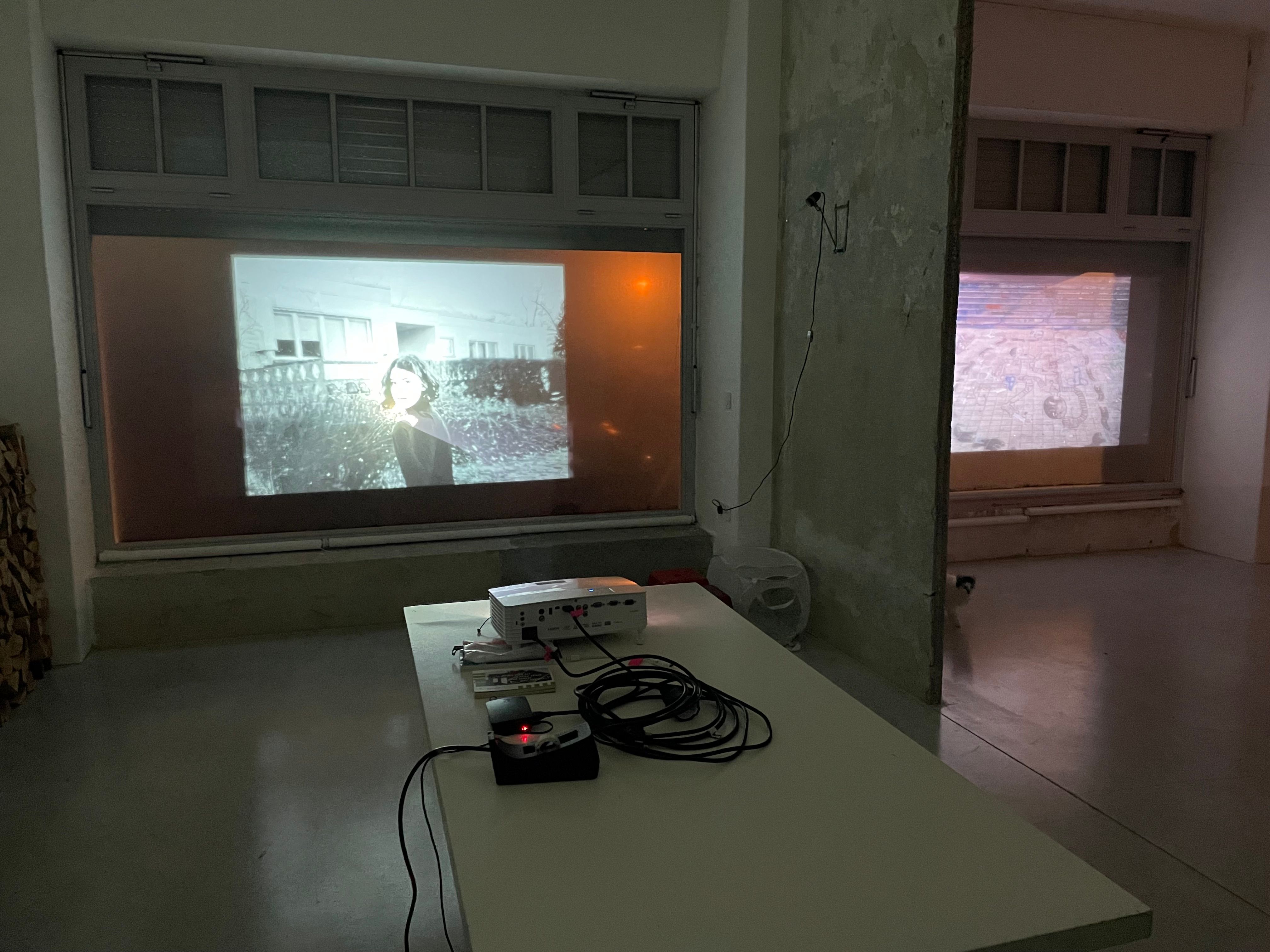 A projector and two images, taken from the inside of the building.