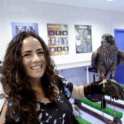 Headshot of Krista Caballero holding a hawk.