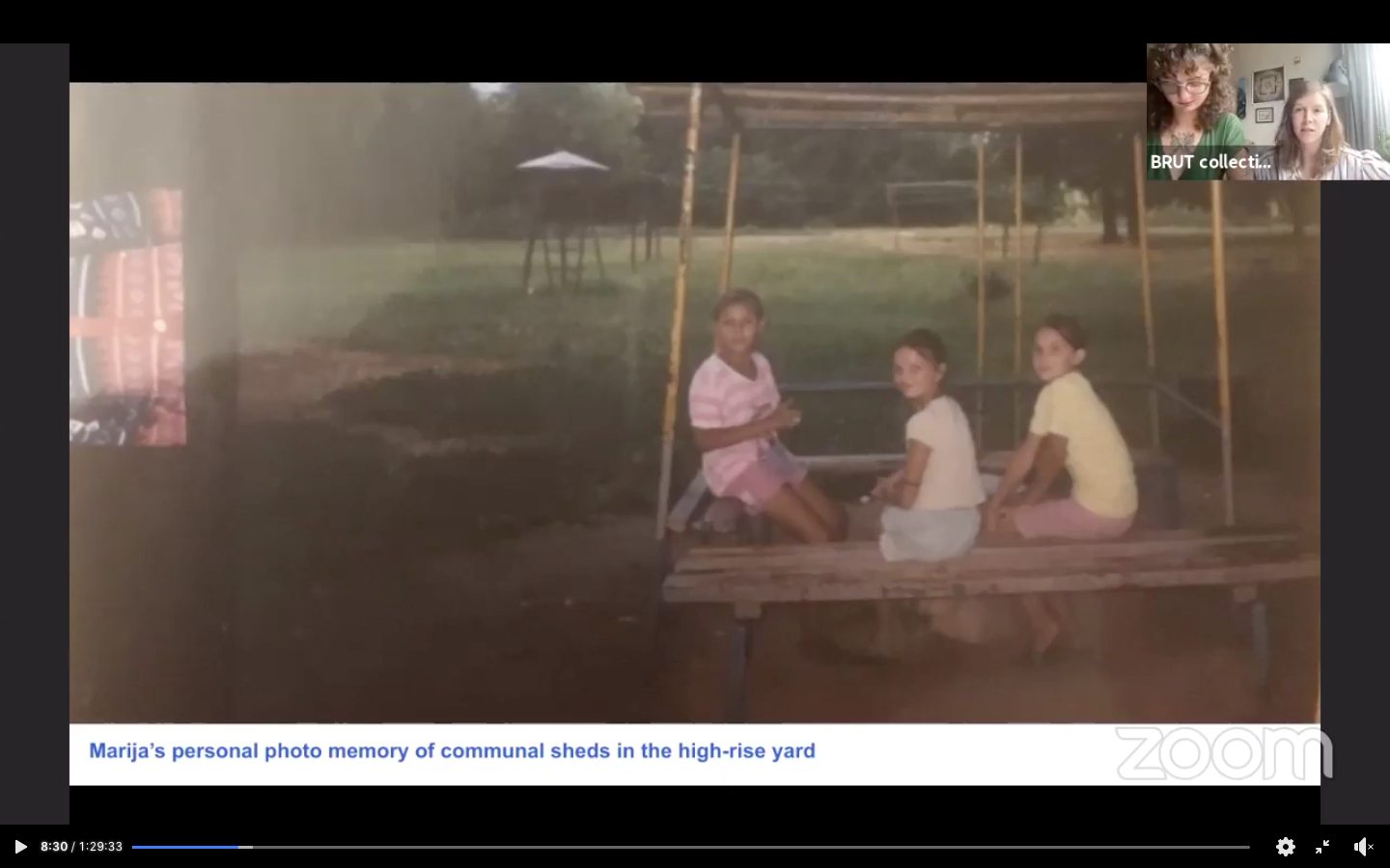 Three young girls sit in a communal shed - benches with a wooden roof - in a high-rise yard