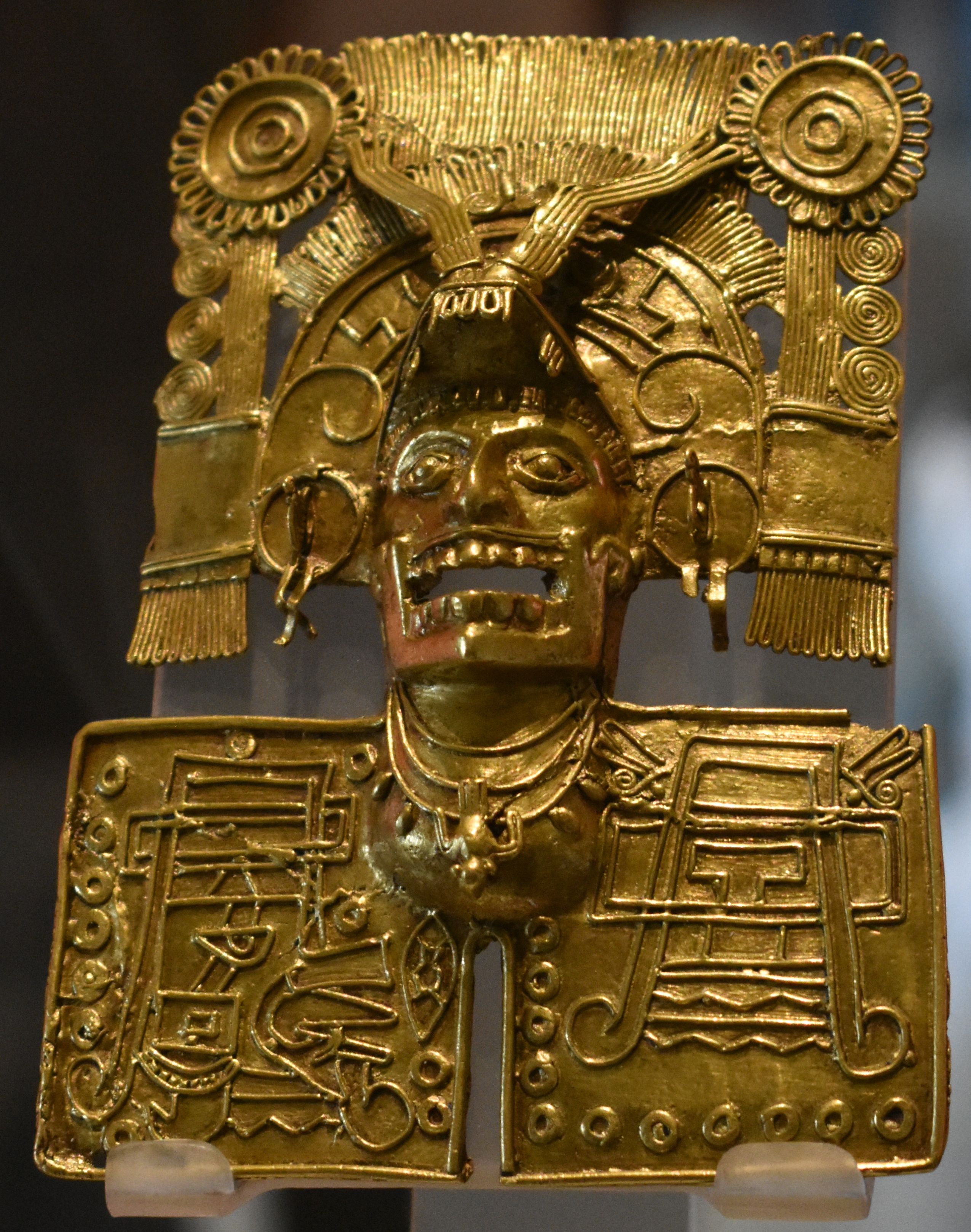 A gold Mixtec pectoral pendant, depicting a man in a headdress and jewelry