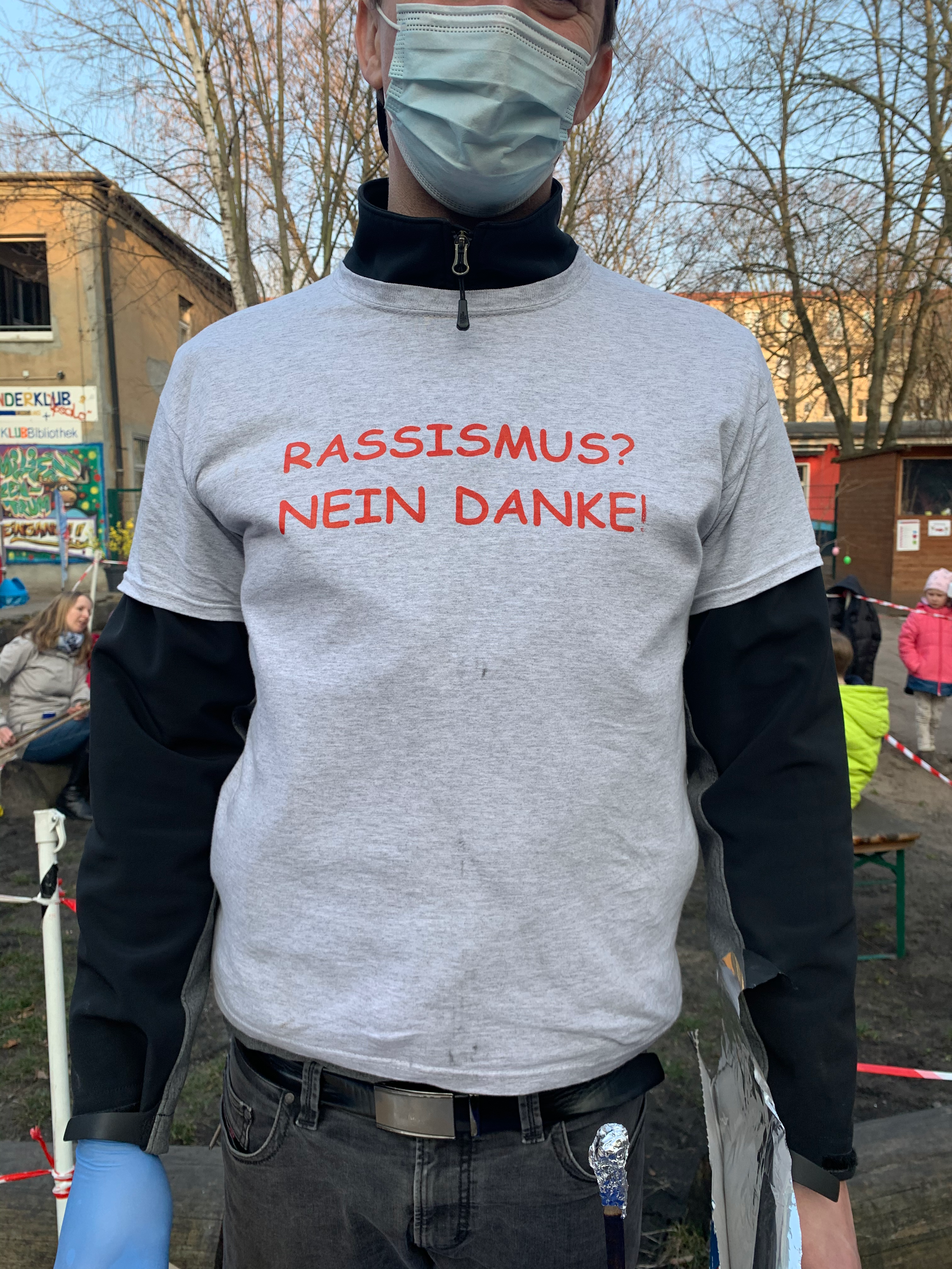 A man wearing a shirt that reads: Rassismus? Nein Danke (Racism? No Thanks)