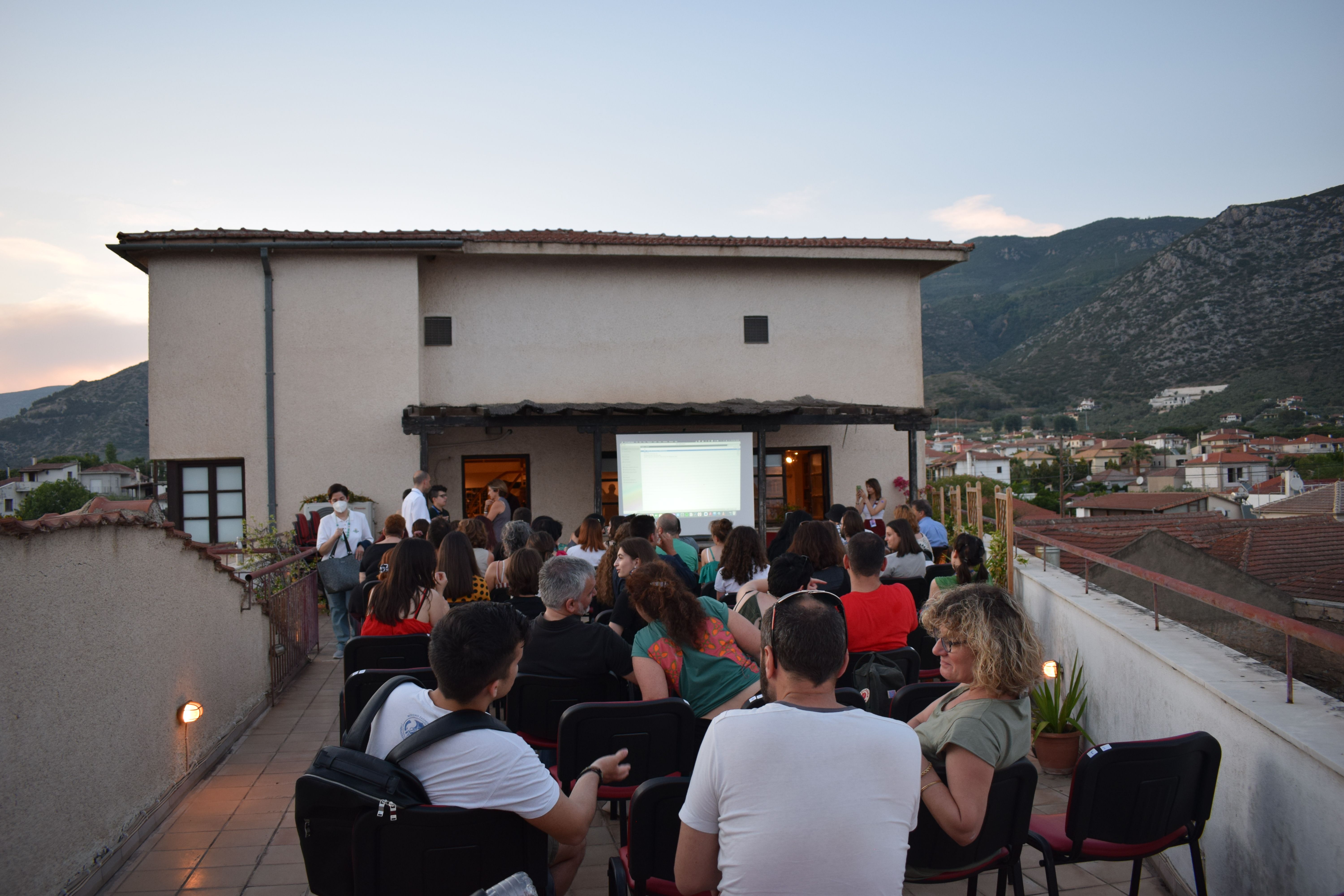 An audience gathered on a roof for an outdoor cinema projection