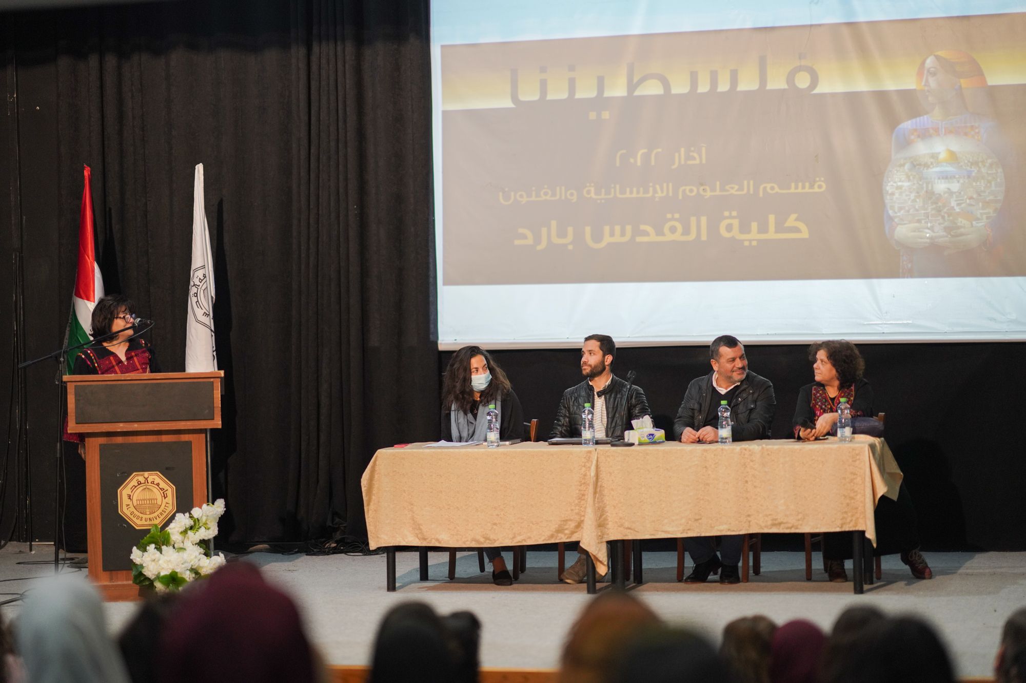 Panel seated at a table moderated by Saida Hamad at the podium.