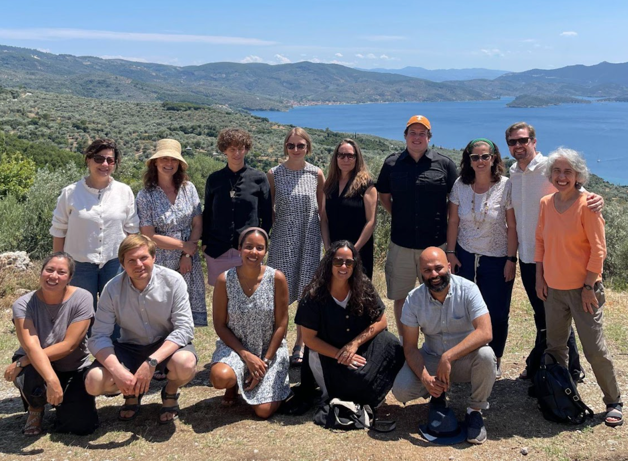 A photograph of members of the EHCN steering committee. They are standing in front of a scenic view in Greece.