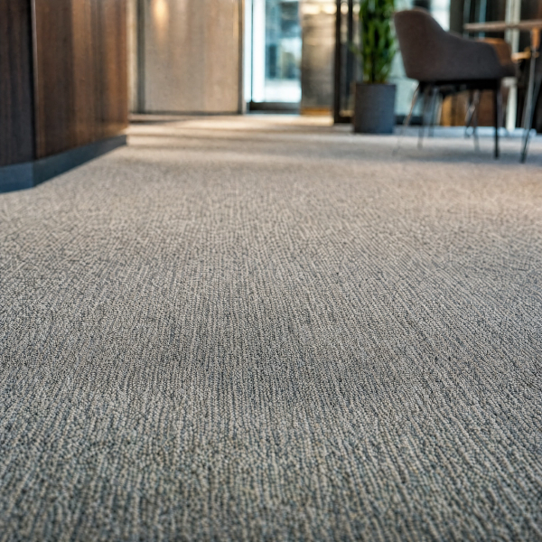 A clean, stain-free carpet in a bright modern office hallway, after cleaning.