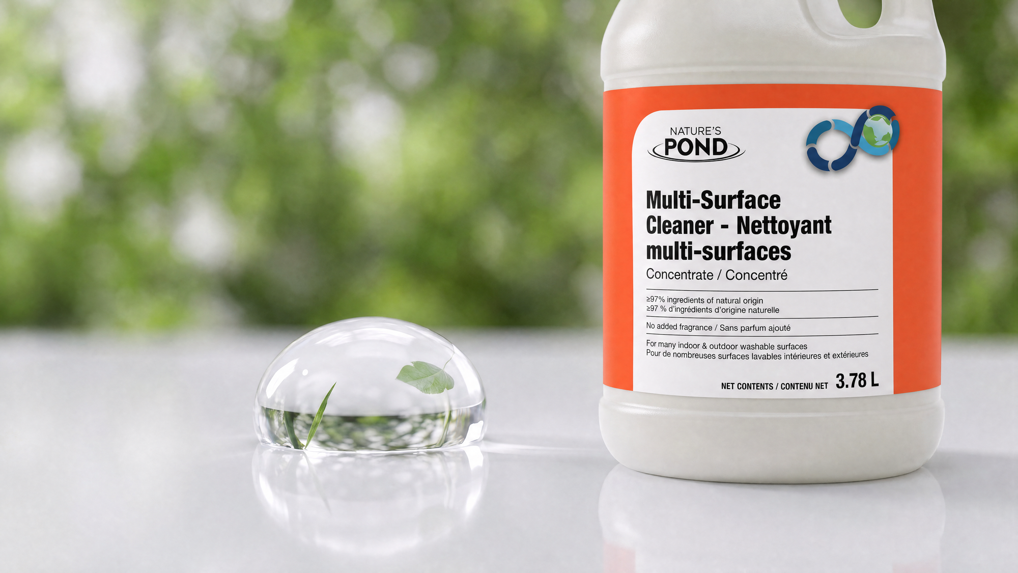A water droplet holding a green leaf beside a Nature’s Pond Multi-Surface Cleaner bottle