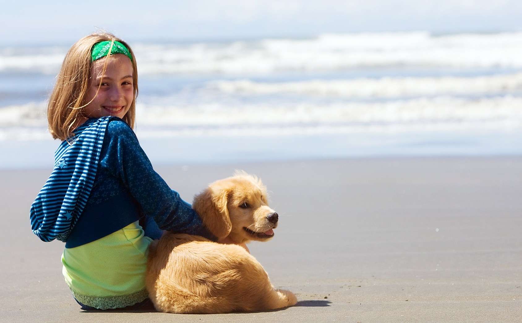 Little girl with her dog on the beach