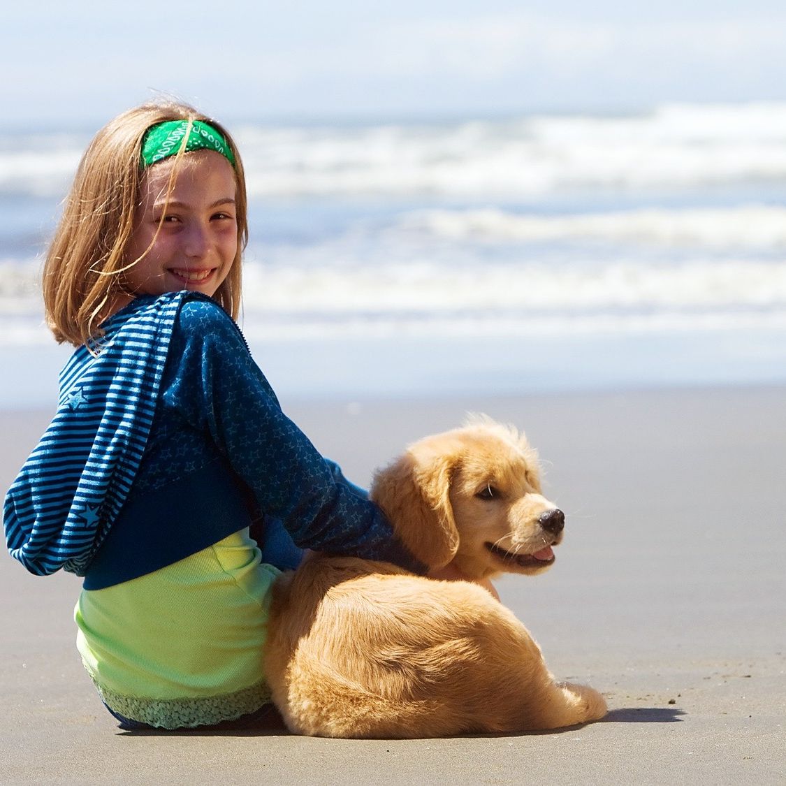 Little girl with her dog on the beach