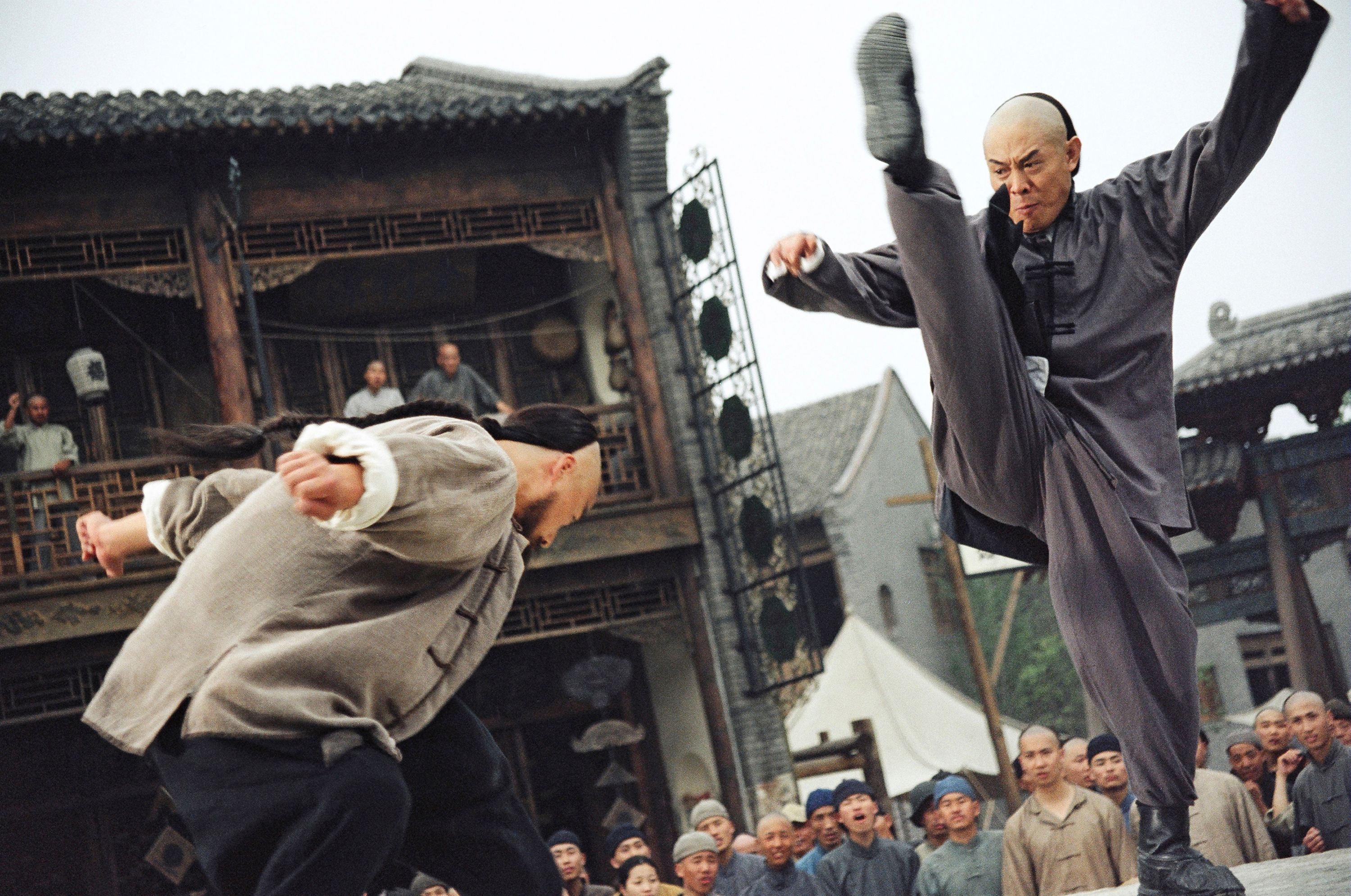 two men fighting with more people watching