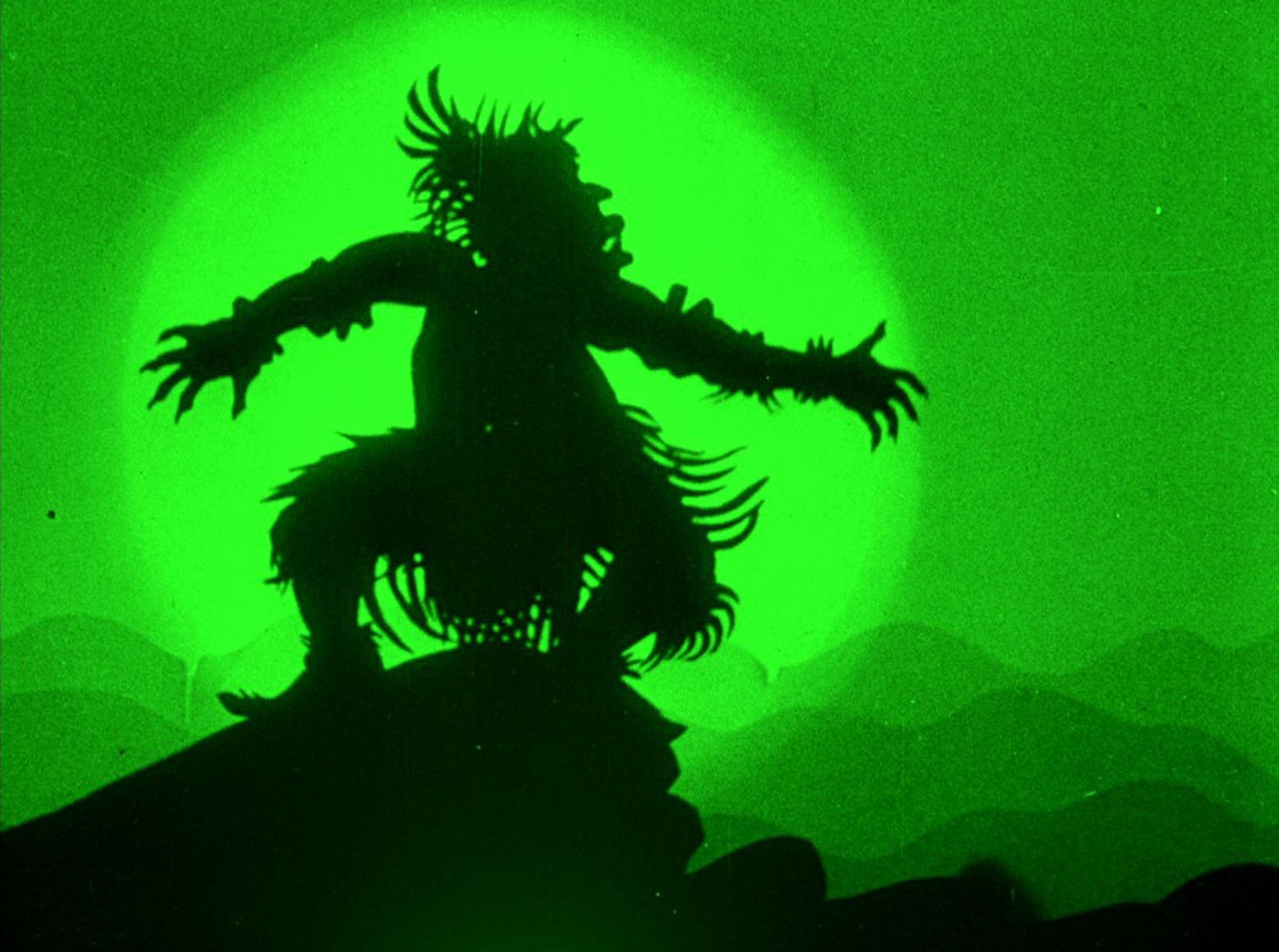 Shadow of a elaborate puppet on a green background