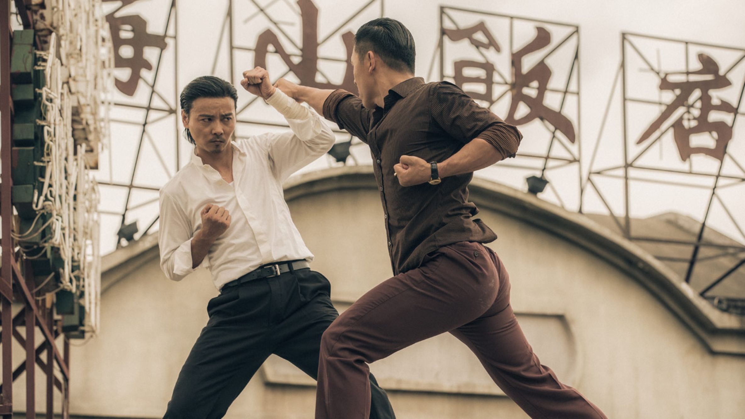 Two men fighting on top of a building