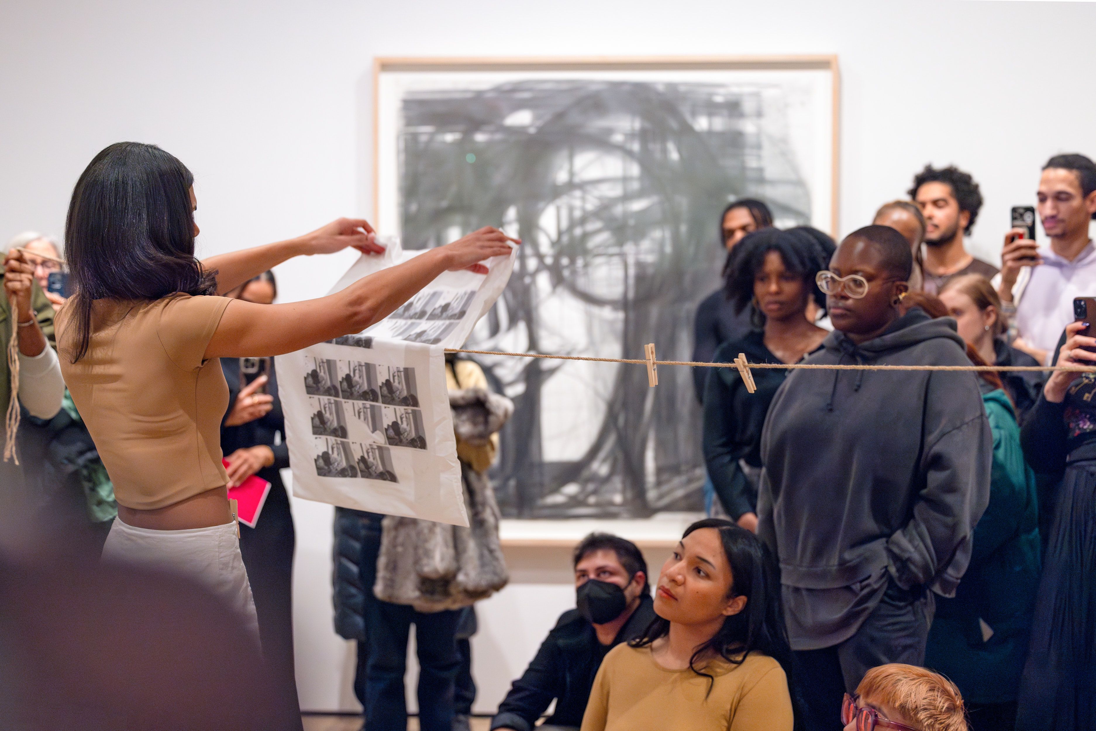 Woman hanging a handmade artwork in front of a group