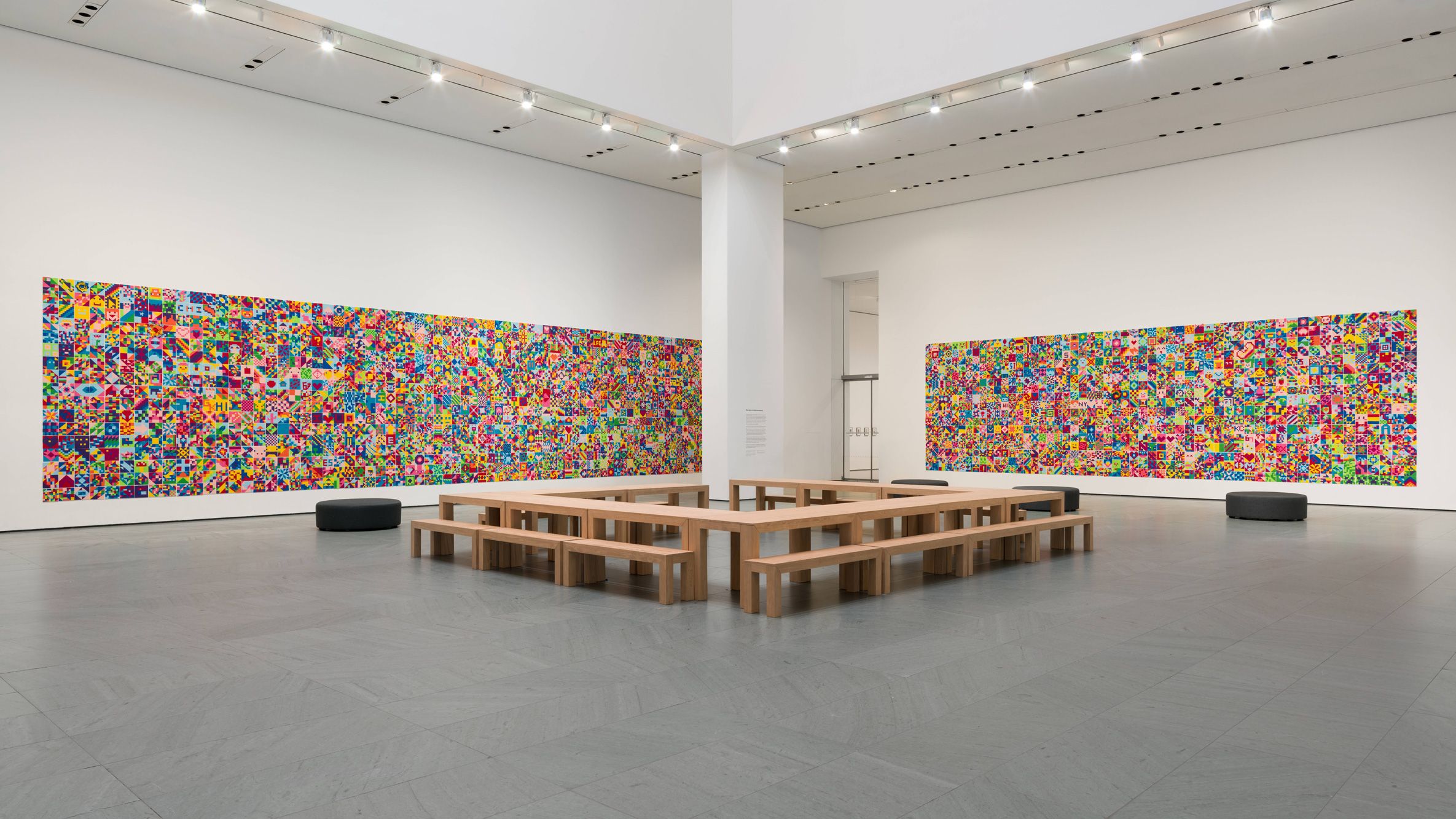 A colorful felt mosaic depicts geometric shapes and patterns. Predominant colors include blue, yellow, pink, and green.