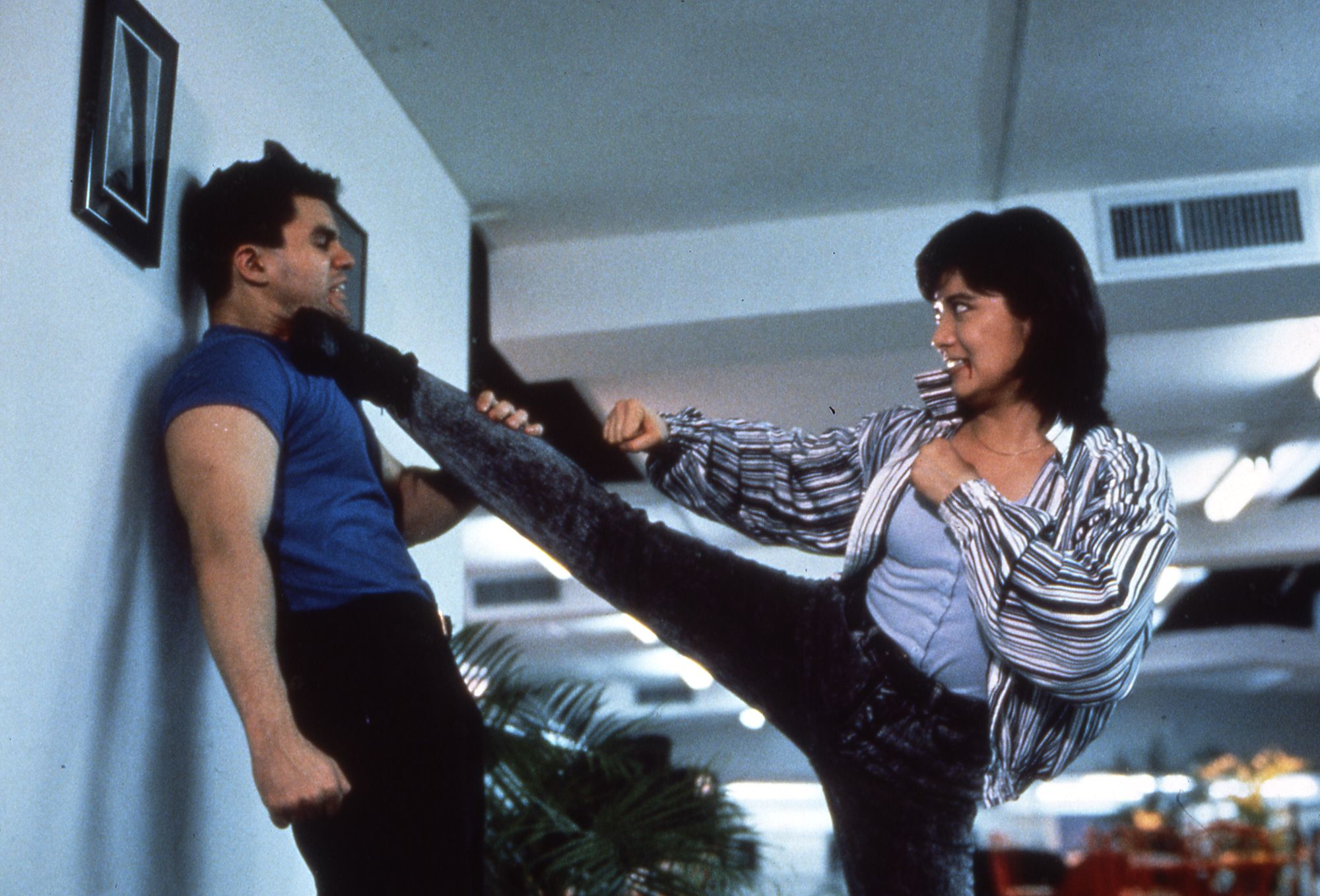 A man kicks another man against a wall